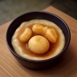 主编林晓澜的工作照，她坐在明亮的编辑台前专注审阅内容词条，桌上摆放着双屏显示器与笔记本，气质沉稳专业